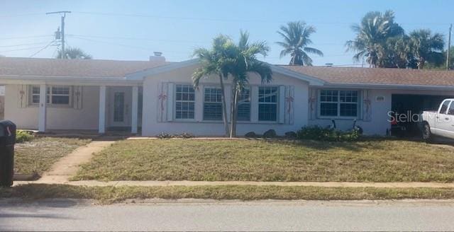 ranch-style home with a garage, stucco siding, and a front lawn