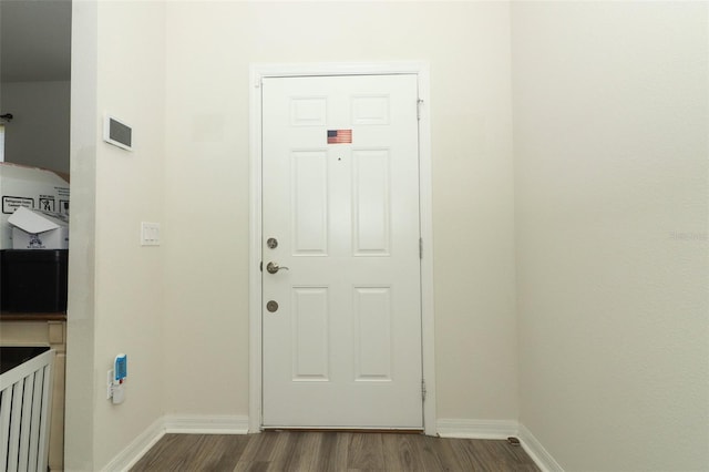 entryway with dark wood-style floors and baseboards