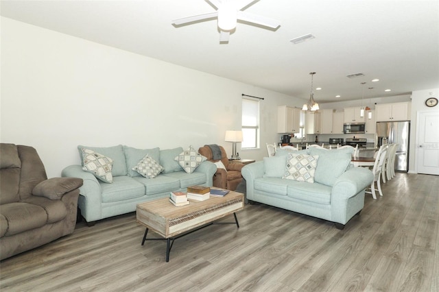 living room featuring recessed lighting, light wood-type flooring, visible vents, and ceiling fan