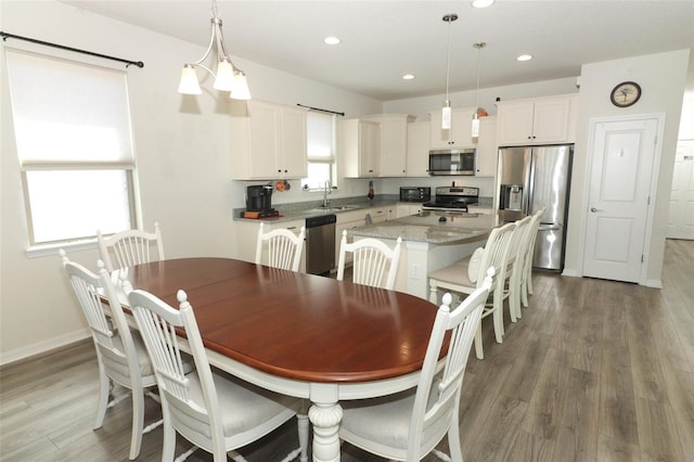 dining space featuring recessed lighting, wood finished floors, and baseboards