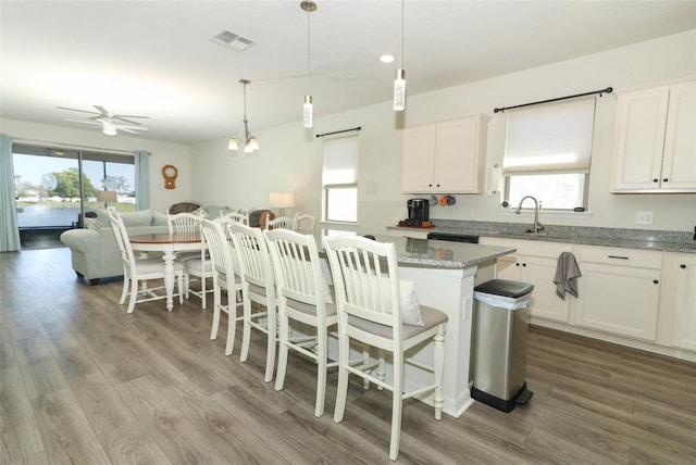 kitchen featuring visible vents, plenty of natural light, wood finished floors, and white cabinetry