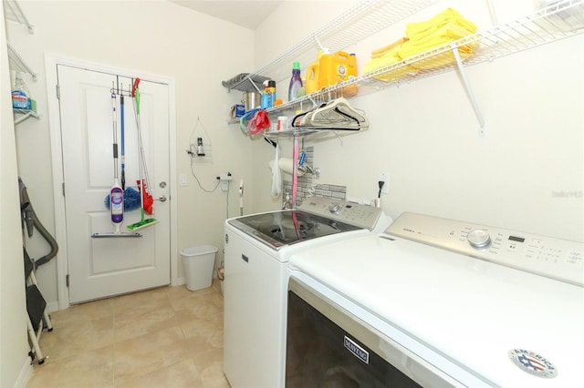 clothes washing area with light tile patterned flooring, laundry area, and washing machine and dryer