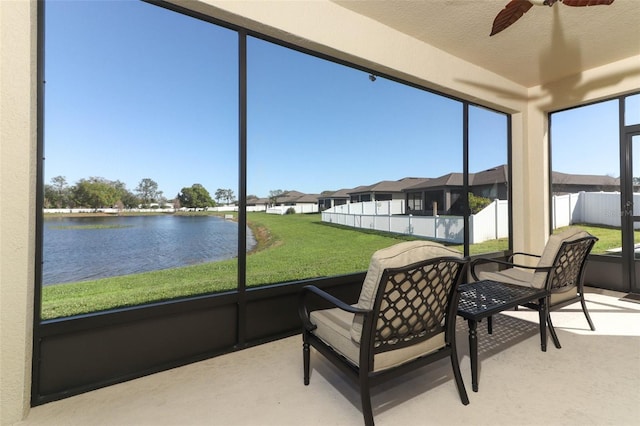 sunroom / solarium with a water view and a ceiling fan