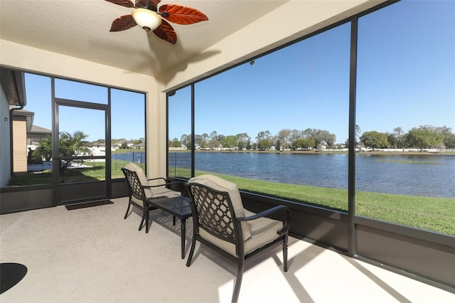 sunroom / solarium featuring a water view and a ceiling fan