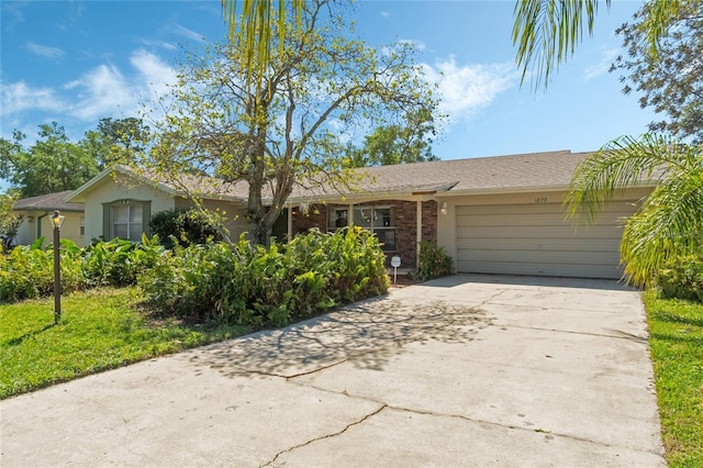 ranch-style home with concrete driveway, brick siding, a garage, and stucco siding