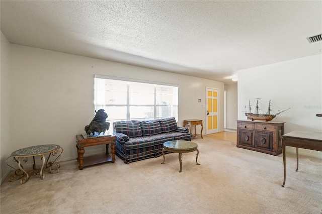 living room featuring visible vents, carpet floors, and a textured ceiling