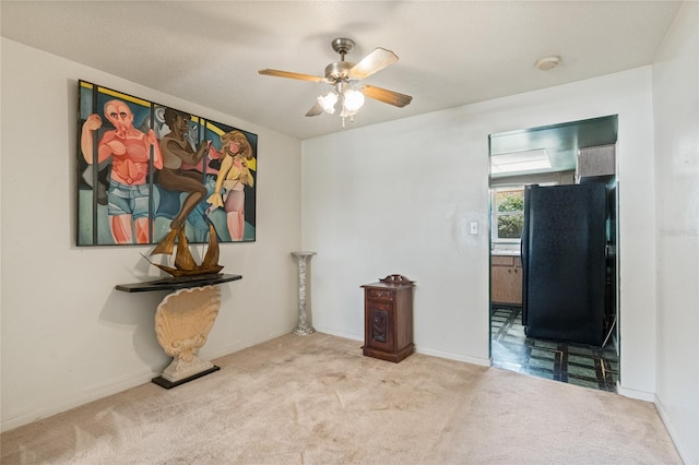 unfurnished room with carpet flooring, a ceiling fan, and baseboards