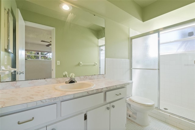 bathroom featuring tile patterned flooring, a shower stall, toilet, and vanity