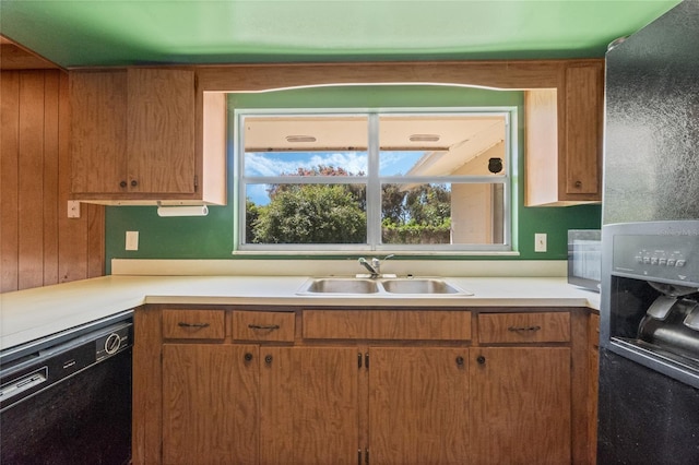 kitchen with light countertops, black dishwasher, refrigerator with ice dispenser, brown cabinetry, and a sink