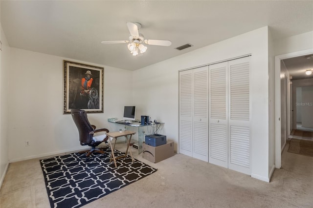 carpeted office featuring baseboards, visible vents, and ceiling fan