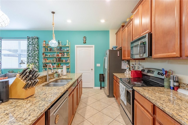 kitchen featuring pendant lighting, a sink, light stone counters, appliances with stainless steel finishes, and light tile patterned floors