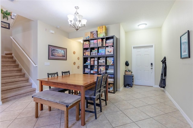 dining area with light tile patterned floors, stairway, baseboards, and a notable chandelier