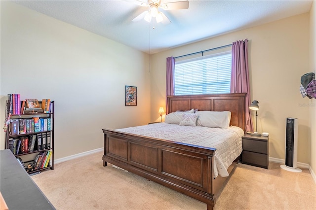 bedroom with light colored carpet, a ceiling fan, and baseboards