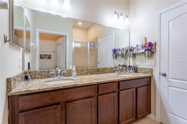 bathroom featuring double vanity, a stall shower, and a sink