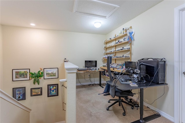 home office with light carpet, a textured ceiling, attic access, and baseboards