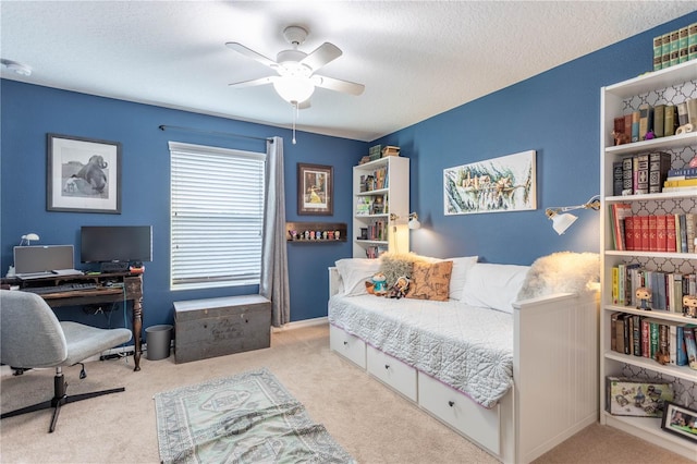 bedroom featuring a ceiling fan, carpet, and a textured ceiling