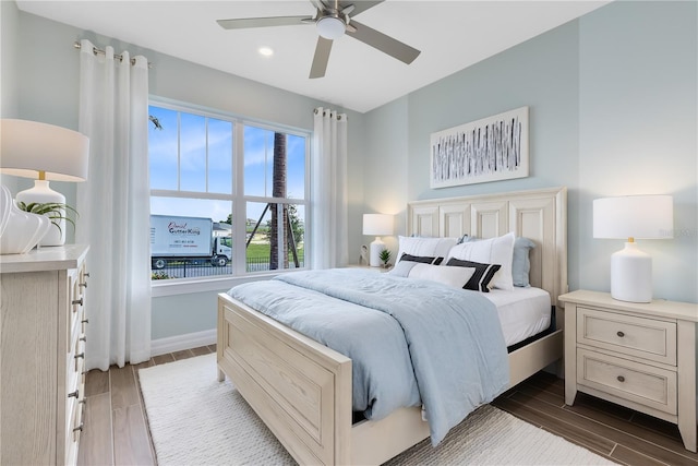 bedroom with ceiling fan, baseboards, and wood finish floors