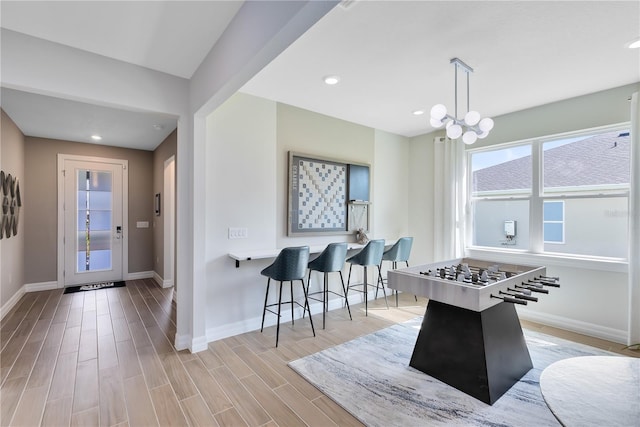 rec room featuring a chandelier, recessed lighting, baseboards, and wood finished floors