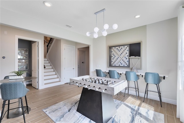 recreation room with wood finish floors, visible vents, baseboards, and recessed lighting