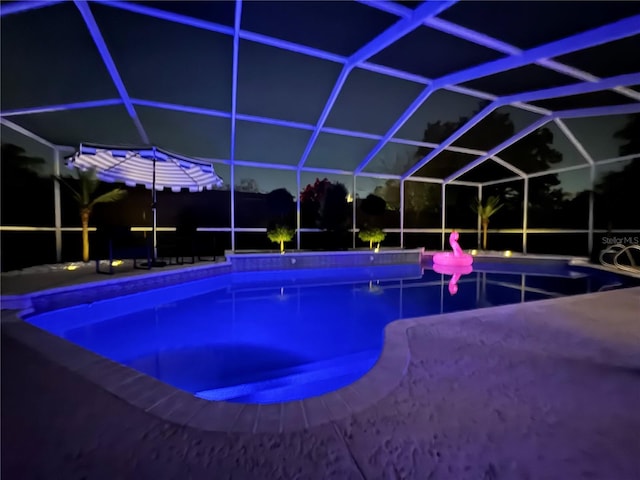 outdoor pool with a patio area and glass enclosure