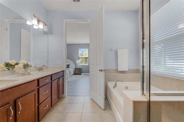 ensuite bathroom featuring a garden tub, visible vents, double vanity, a sink, and tile patterned floors