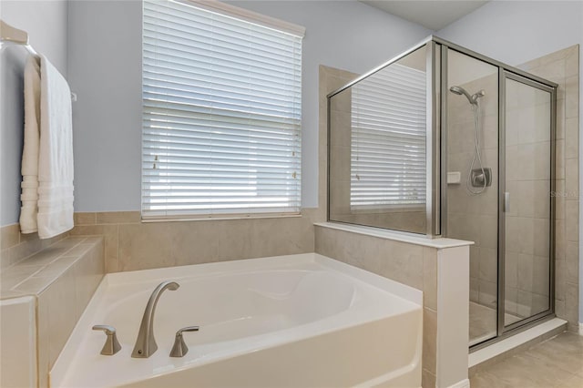 bathroom featuring a shower stall and a bath