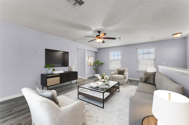 living room with visible vents, baseboards, a ceiling fan, and wood finished floors