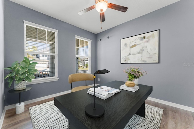 office area with baseboards, ceiling fan, and wood finished floors