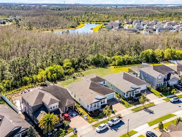 aerial view with a residential view, a view of trees, and a water view