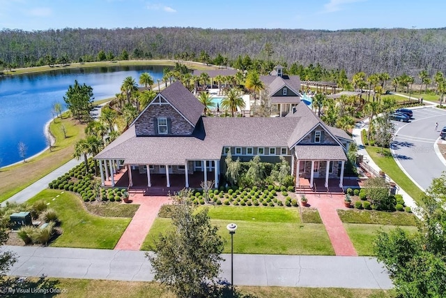 birds eye view of property with a water view and a wooded view