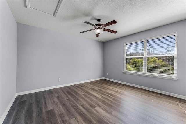 spare room with baseboards, attic access, wood finished floors, a textured ceiling, and a ceiling fan