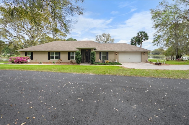 single story home with stucco siding, driveway, a front lawn, and a garage