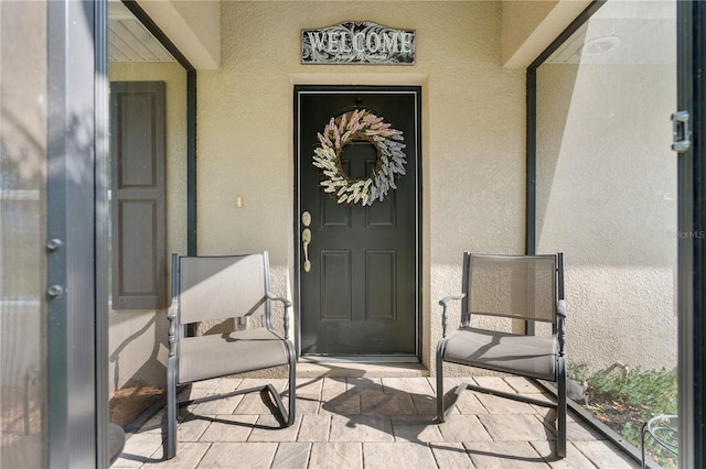 entrance to property featuring stucco siding