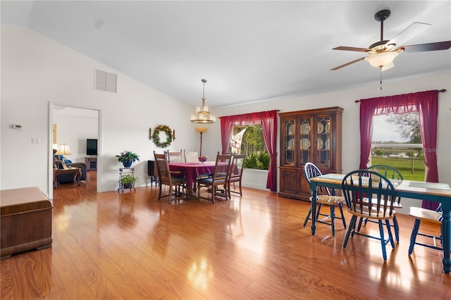 dining space featuring light wood finished floors, visible vents, high vaulted ceiling, and a ceiling fan