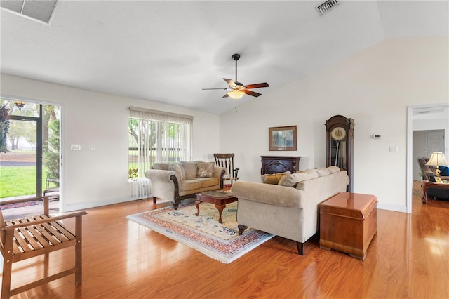 living room with visible vents, light wood-style flooring, and vaulted ceiling