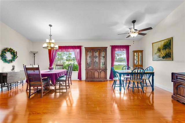 dining area with baseboards, lofted ceiling, ceiling fan, and light wood finished floors