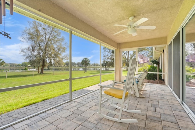 unfurnished sunroom featuring a ceiling fan