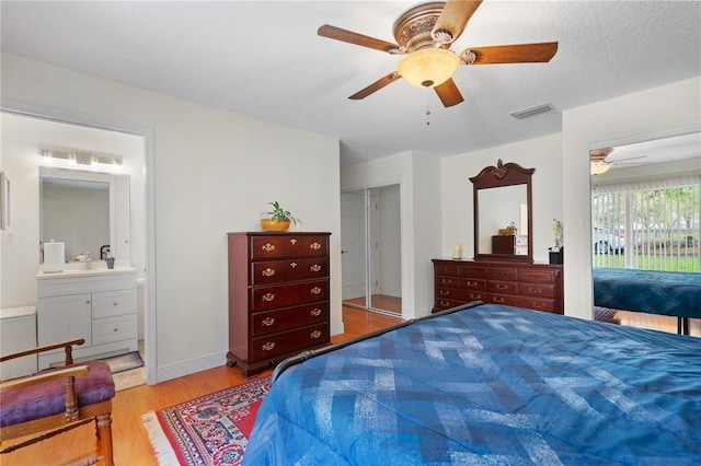 bedroom featuring wood finished floors, visible vents, a sink, access to outside, and connected bathroom