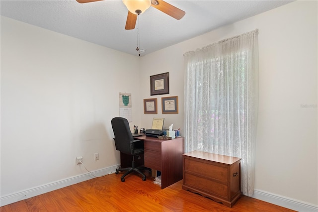 office with baseboards, light wood-style flooring, and a ceiling fan