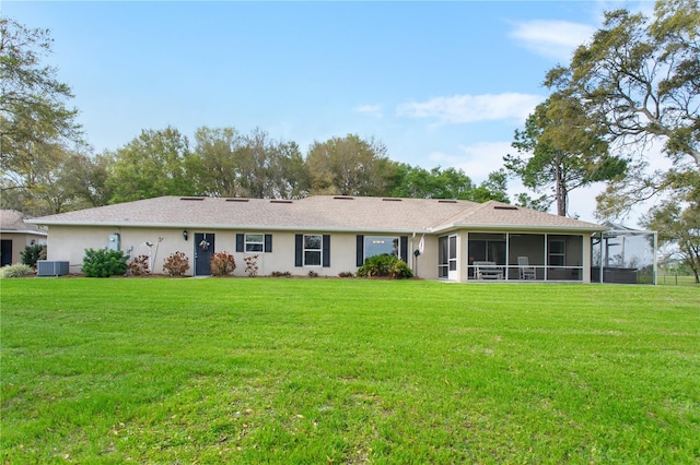 back of property with stucco siding, central AC unit, a yard, and a sunroom