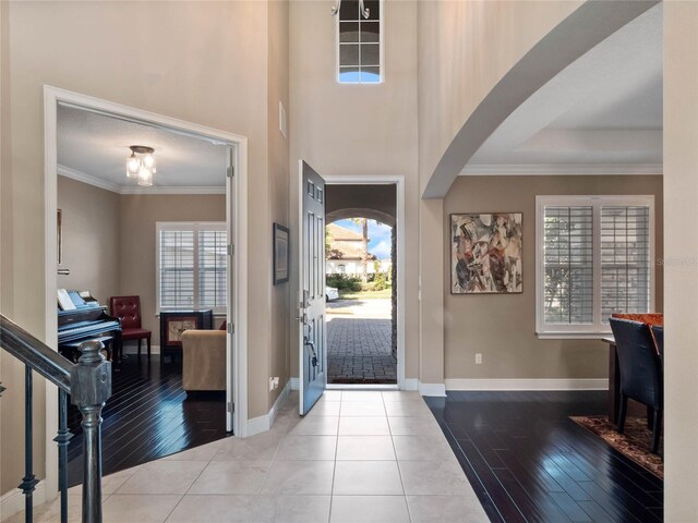 entrance foyer with baseboards, plenty of natural light, and crown molding