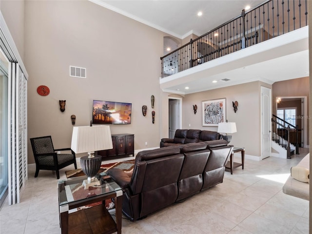 living area with visible vents, baseboards, stairway, ornamental molding, and a towering ceiling