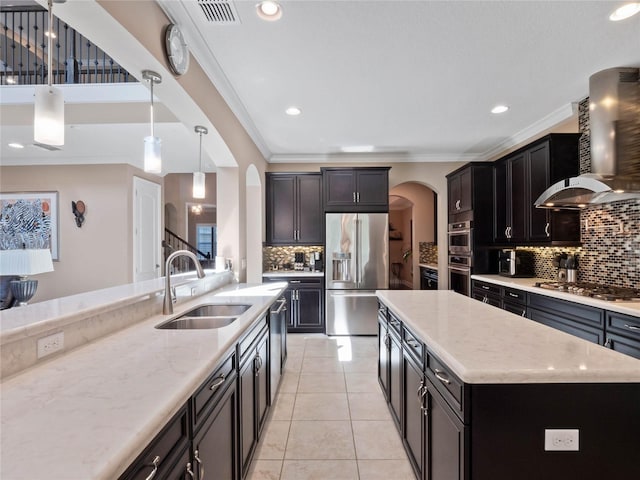 kitchen featuring arched walkways, ornamental molding, a sink, appliances with stainless steel finishes, and wall chimney exhaust hood