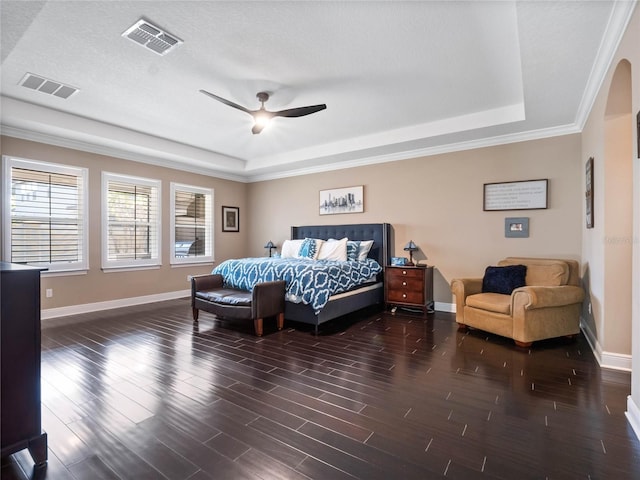 bedroom featuring a raised ceiling, wood finished floors, and visible vents