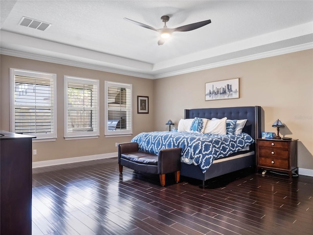 bedroom with visible vents, ceiling fan, baseboards, wood finished floors, and a raised ceiling