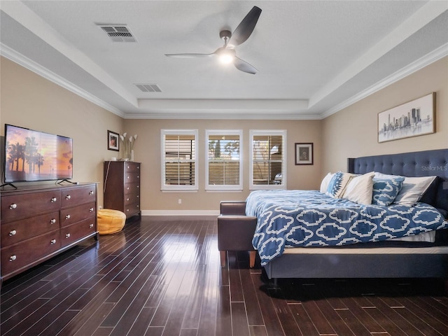 bedroom featuring a tray ceiling, visible vents, and dark wood-style flooring