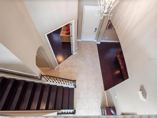 staircase featuring baseboards and an inviting chandelier