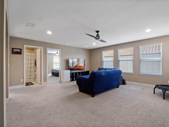 living room featuring carpet, baseboards, visible vents, recessed lighting, and a textured ceiling