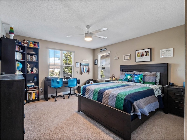 carpeted bedroom with baseboards, multiple windows, a textured ceiling, and a ceiling fan