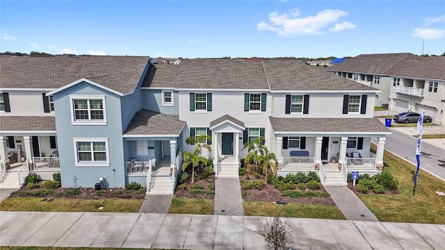 multi unit property with a porch, a residential view, and stucco siding